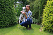 Mann kuschelt mit Hund im Garten