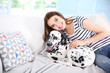 Owner with her dalmatian dog sitting on a couch